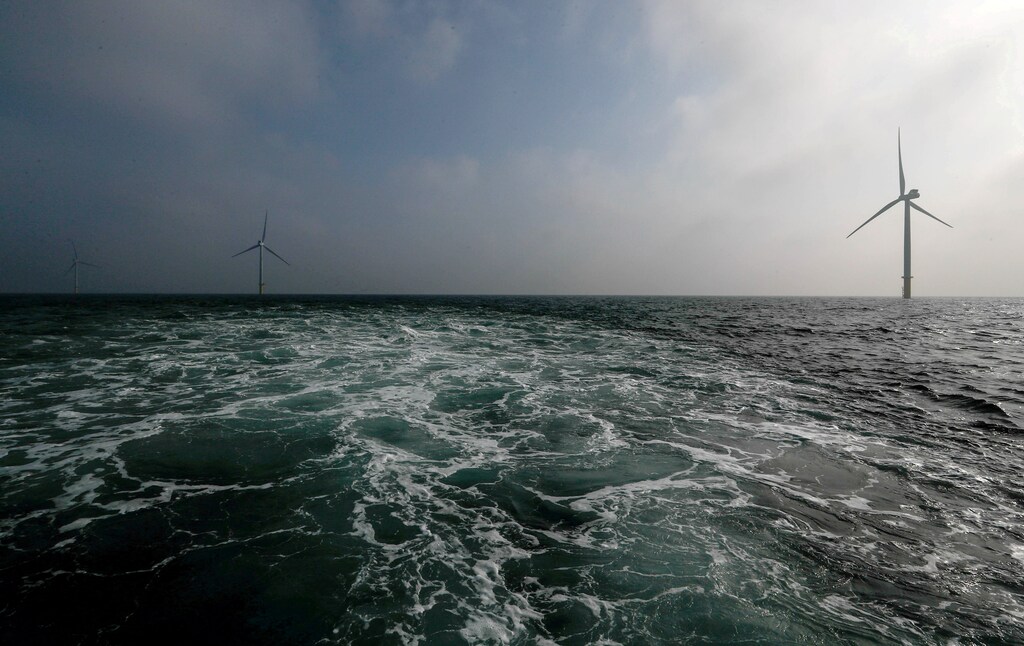 Power-generating windmill turbines are seen out a sea.