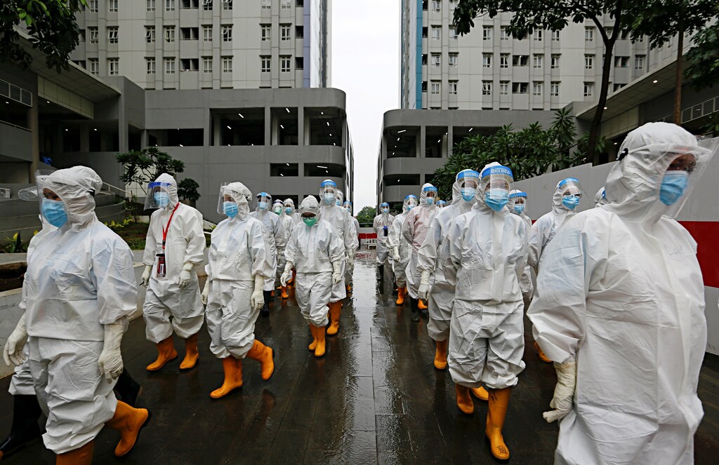 Healthcare workers wearing personal protective equipment (PPE) prepare to treat patients at the emergency hospital for coronavirus disease (COVID-19) in Athletes Village, Jakarta, Indonesia January 26, 2021. REUTERS/Ajeng Dinar Ulfiana TPX IMAGES OF THE DAY - RC2LFL9HEVAO