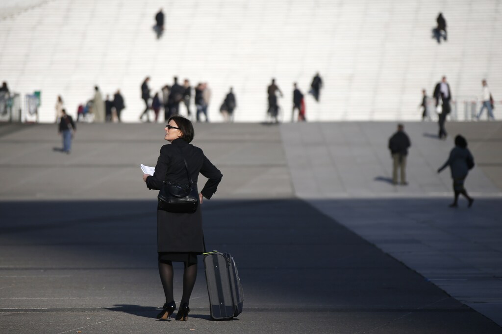 A businesswoman walks on the esplanade of La Defense, in the financial and business district in La Defense, west of Paris April 10, 2014. REUTERS/Gonzalo Fuentes (FRANCE - Tags: BUSINESS) - RTR3KUFS
