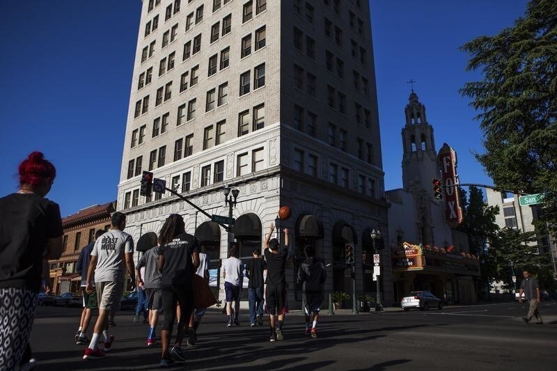 Pedestrians cross a street in downtown Stockton, California, May 13, 2014. The bankrupt city will face off against a holdout creditor this week in a closely watched municipal bankruptcy case pitting the rights of impaired bondholders against retirees and other creditors. REUTERS/Max Whittaker (UNITED STATES - Tags: BUSINESS POLITICS CRIME LAW) - GM1EA5E0H6M01