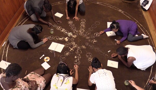 Refugee women making a large canvas ‘story cloth’ to share their personal journeys.