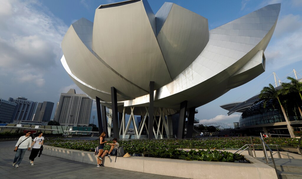 People walk past the ArtScience Museum in Singapore April 10, 2017.