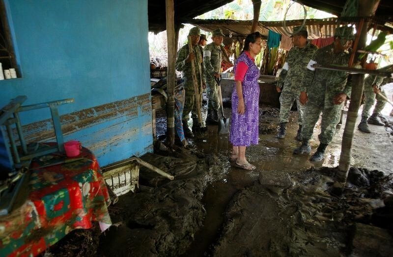 A woman chats with soldiers at her house damaged by floodings caused by the rains of Tropical Storm Beatriz in Santa Maria Tonameca, in Oaxaca state, Mexico, June 2, 2017. REUTERS/Jorge Luis Plata - RC1B2878F1C0