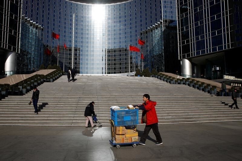 A delivery worker pushes a trolley loaded with parcels past the Grand Hyatt hotel in Beijing, December 4, 2018. REUTERS/Thomas Peter - RC12D203E640