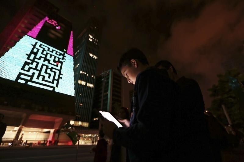 A boy uses an iPad to play a video game, which is projected onto the surface of the Fiesp building, headquarters of the Industry Federation of Sao Paulo, during the "Play!" exhibition in the financial center of Sao Paulo's Avenida Paulista March 27, 2013.