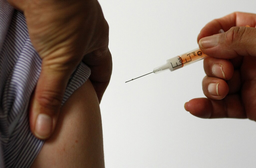 A nurse is given the vaccine against the H1N1 swine flu during a vaccination session for front line medical staff at the Countess of Chester Hospital in Chester, northern England, November 6, 2009. REUTERS/Phil Noble (BRITAIN HEALTH SOCIETY) - GM1E5B61RXY01