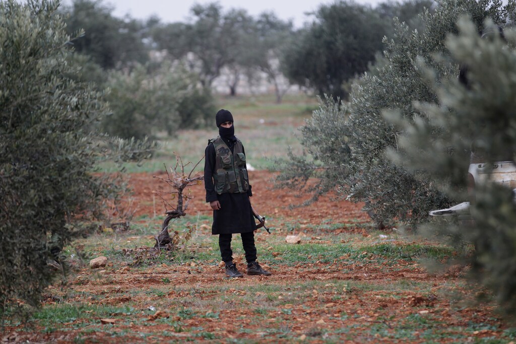 A member of al Qaeda's Nusra Front carries his weapon as he stands in an olive tree field, near villages which the Nusra Front said they have seized control of from Syrian rebel factions, in the southern countryside of Idlib, December 2, 2014. Picture taken December 2, 2014. REUTERS/Khalil Ashawi (SYRIA - Tags: CIVIL UNREST CONFLICT TPX IMAGES OF THE DAY) - GM1EAC31HVM01