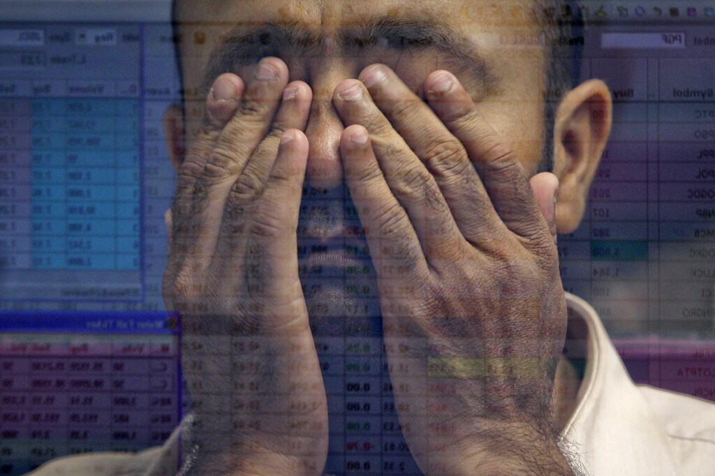 The reflection of a stockbroker in a glass panel shows him reacting as he observes the latest share prices during a trading session at the Karachi Stock Exchange May 24, 2011. REUTERS/Akhtar soomro (PAKISTAN - Tags: BUSINESS HEADSHOT) - GM1E75O1AGL01