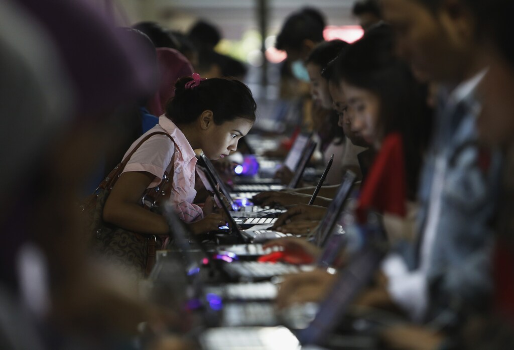 Indonesian youths stand in a line as they fill up job application forms at Kompas Karier Fair in Jakarta August 30, 2013.