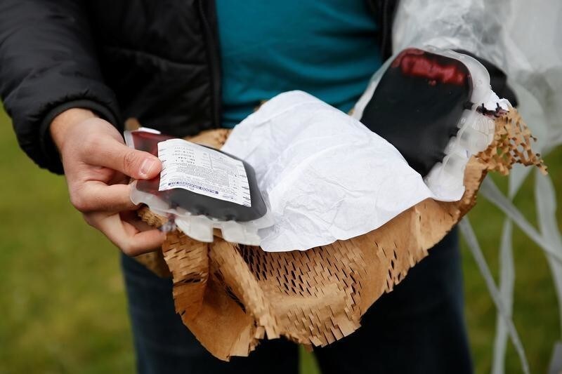 Keenan Wyrobek, head of product engineering at Zipline International, displays a package of fake blood airdropped by a Zipline drone during a flight demonstration at an undisclosed location in the San Francisco Bay Area, California, U.S., May 5, 2016. REUTERS/Stephen Lam - S1AETDANIRAB