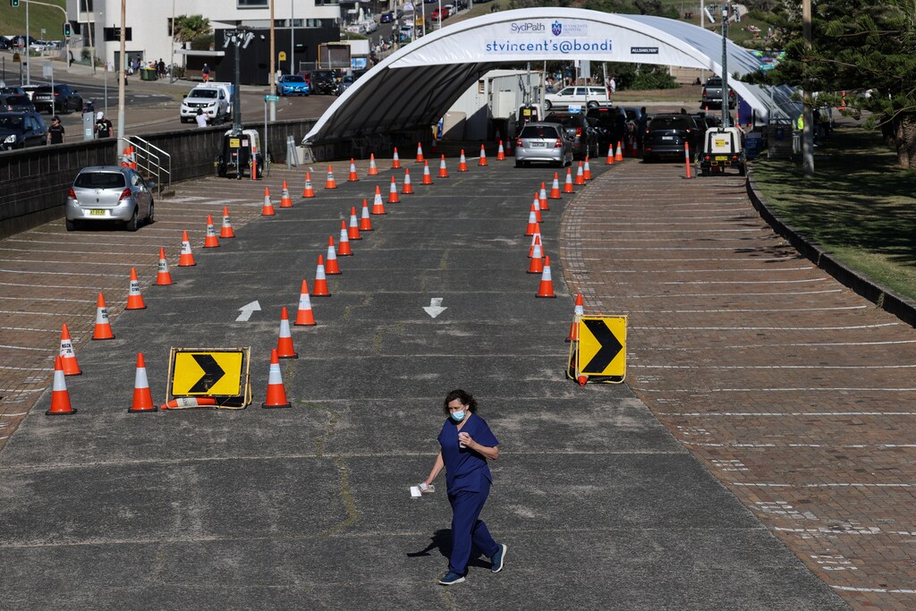 A health worker walks from the Bondi Beach drive-through COVID-19 testing centre during a coronavirus disease outbreak lockdown in Sydney, Australia, October 5, 2021. REUTERS/Loren Elliott - RC2H3Q9ZA7ER