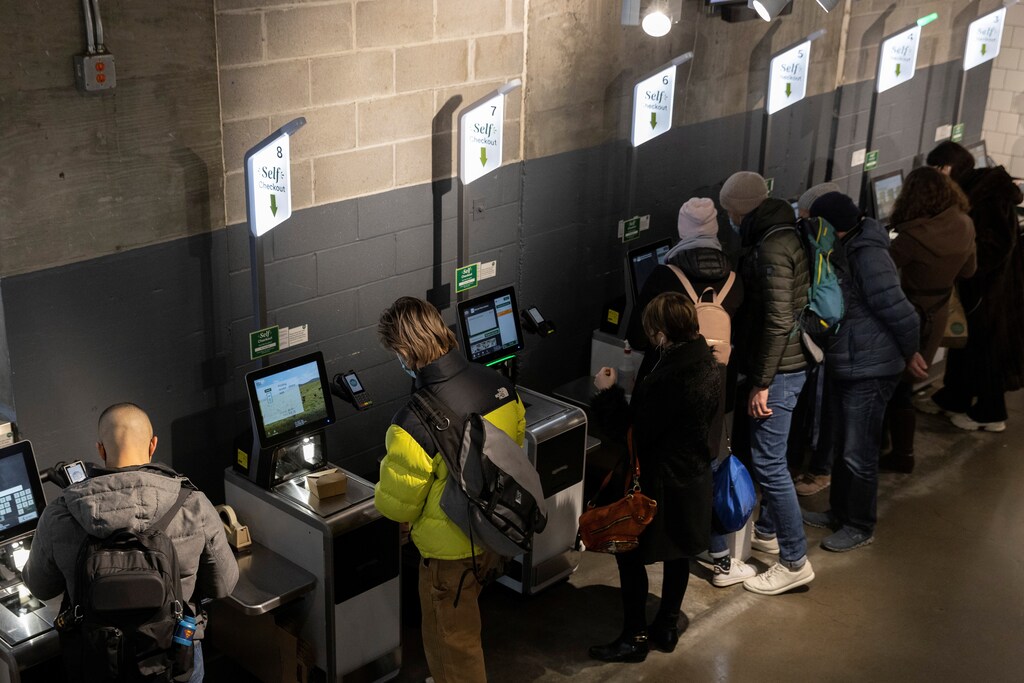 People pay for their purchases with self-checkout at a supermarket in Manhattan, New York City, U.S., March 28, 2022. REUTERS/Andrew Kelly