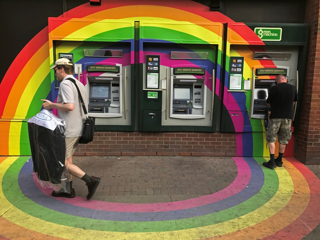 A customer withdraws money from an ATM at a Toronto-Dominion Bank (TD) branch adorned with colours of the Pride rainbow flag symbolizing gay rights, in downtown Toronto, Ontario, Canada June 13, 2017. Picture taken June 13, 2017. REUTERS/Chris Helgren - RC17F8D37AB0