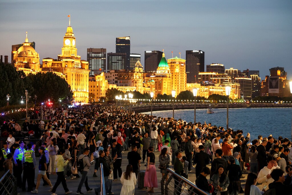 Personas disfrutan de las luces de la ciudad durante los cinco días festivos del Día del Trabajo en Shanghái, China, el 4 de mayo de 2025.