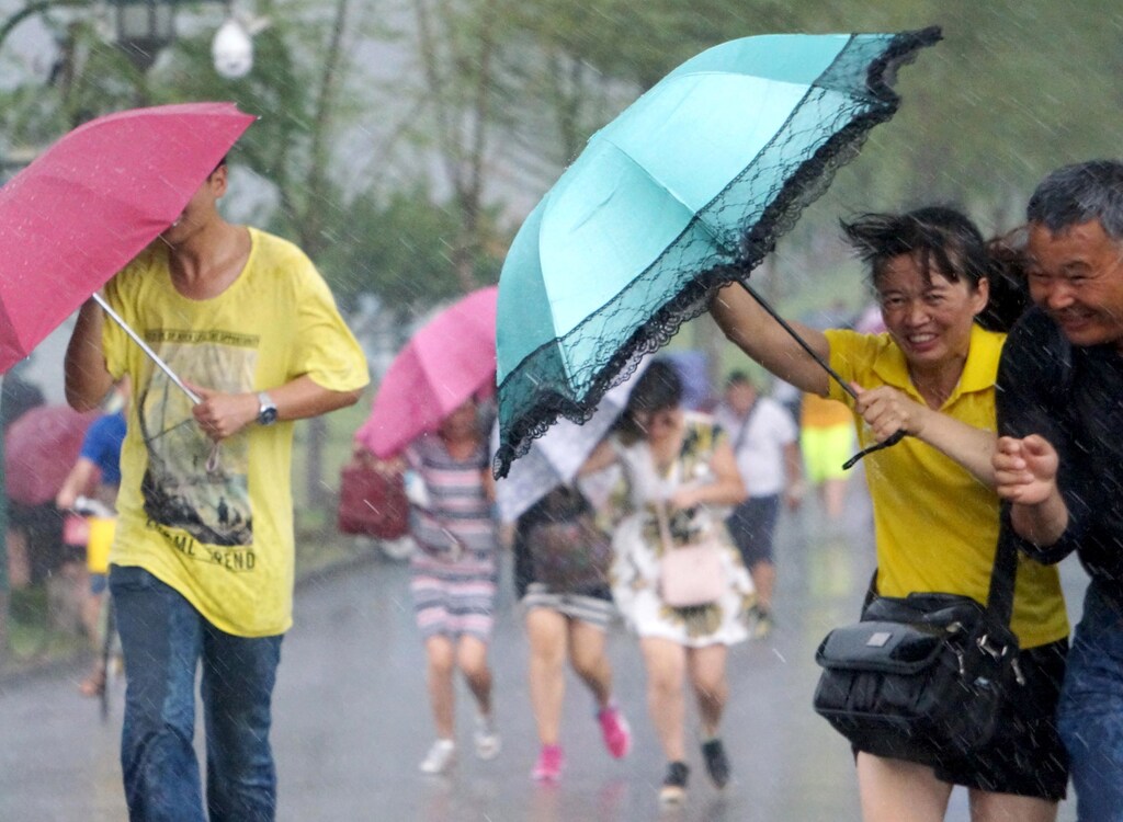 People hold umbrellas in heavy rain as Typhoon Soudelor approaches, in Hangzhou, Zhejiang province, August 7, 2015. Taiwan evacuated hundreds of people from their homes on Friday as the strongest typhoon to threaten the island in two years churned towards it and was expected to make landfall early on Saturday. After passing over Taiwan, the typhoon is expected to cross the Taiwan Strait and hit the Chinese province of Fujian, where the government has begun evacuating people who live on the coast. REUTERS/Stringer CHINA OUT. NO COMMERCIAL OR EDITORIAL SALES IN CHINA - RTX1NG0W
