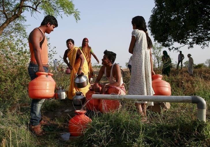 Residents wait to fill their containers with water in a field in Latur, India, April 17, 2016. REUTERS/Danish Siddiqui