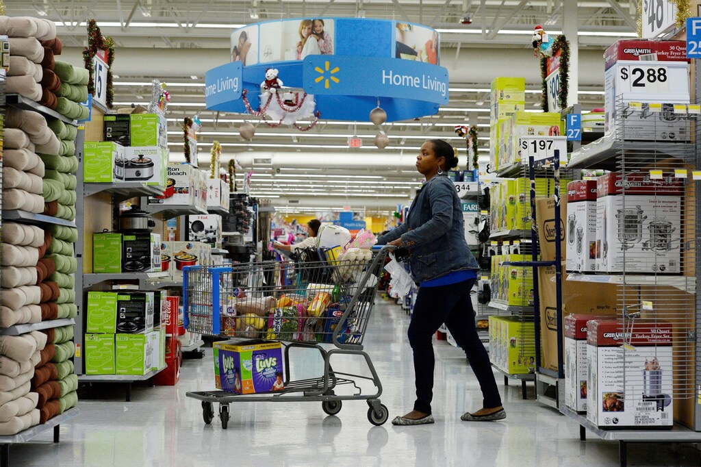 A customer pushes her shopping cart through the aisles at a Walmart store in the Porter Ranch section of Los Angeles.