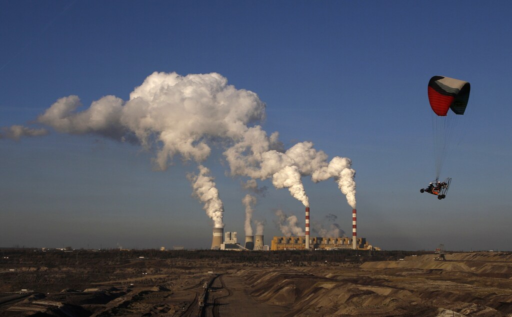 A motor glider flies near the Belchatow Coal Mine, the biggest opencast mine of brown coal in Poland, outside of Belchatow Power Station, Europe's largest coal-fired power plant, in Belchatow October 31, 2013. The 19th conference of the United Nation Framework Convention on Climate Change will begin in Warsaw from Monday, November 11. Picture taken October 31, 2013. REUTERS/Kacper Pempel