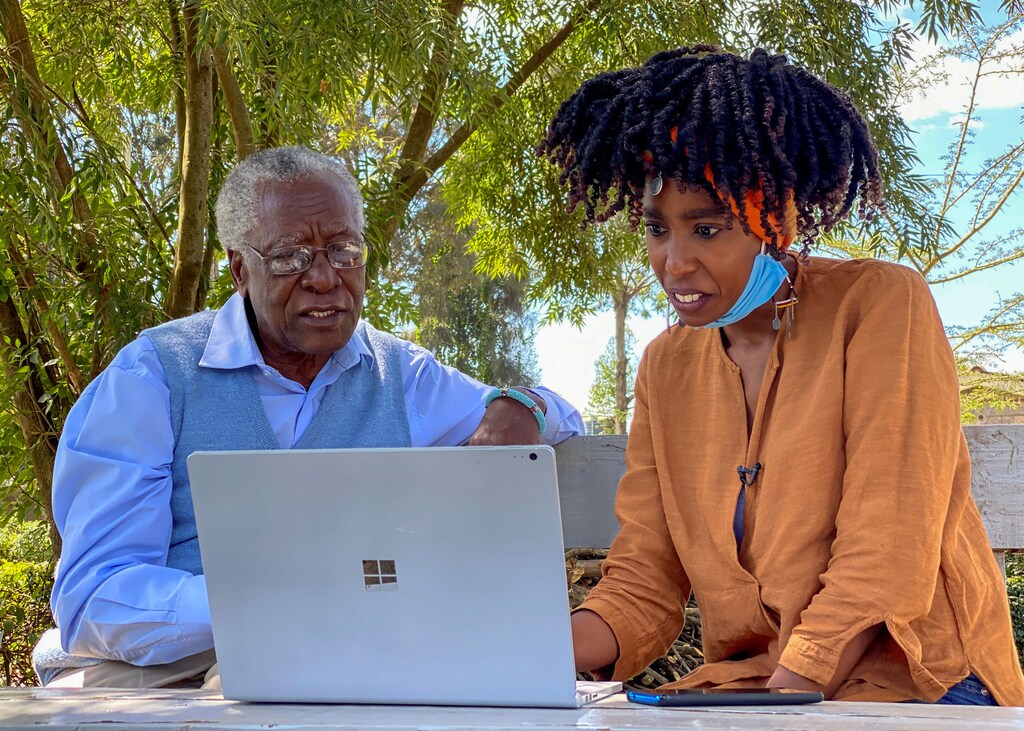 Chao Tayiana, a digital historian, and her grandfather Daniel Sindiyo, whose mother was in the British detention camps of the pre-independence Mau Mau rebellion, look at the reconstructed 3D models of the detention camps, during a Reuters interview in Ngong, outside Nairobi, Kenya June 29, 2020. Picture taken June 29, 2020. REUTERS/Edwin Waita - RC2OPH95W4WR