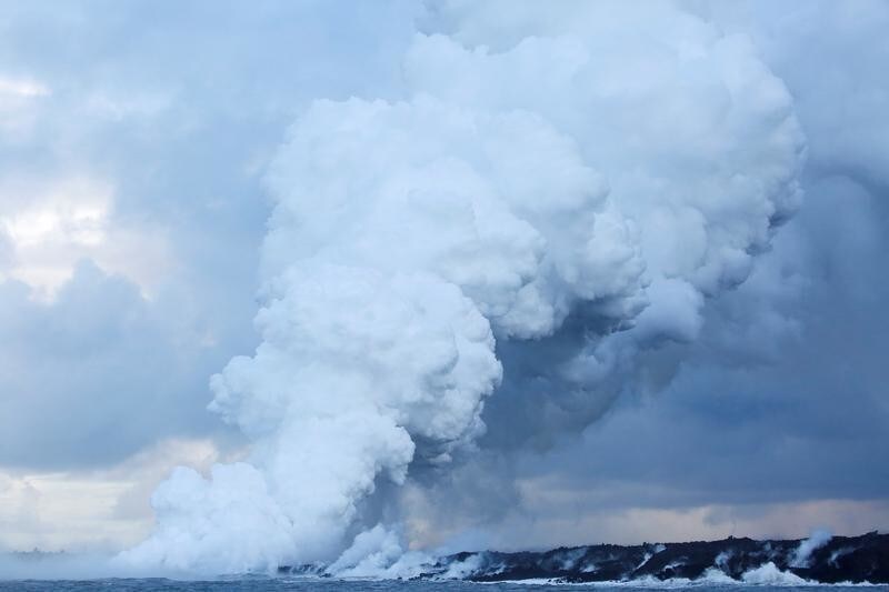 A plume of laze, composed of steam, acid and volcanic glass, rises into the sky as lava flows into the Pacific Ocean in the Kapoho area, on the outskirts of Pahoa, during ongoing eruptions of the Kilauea Volcano in Hawaii, U.S., June 7, 2018.