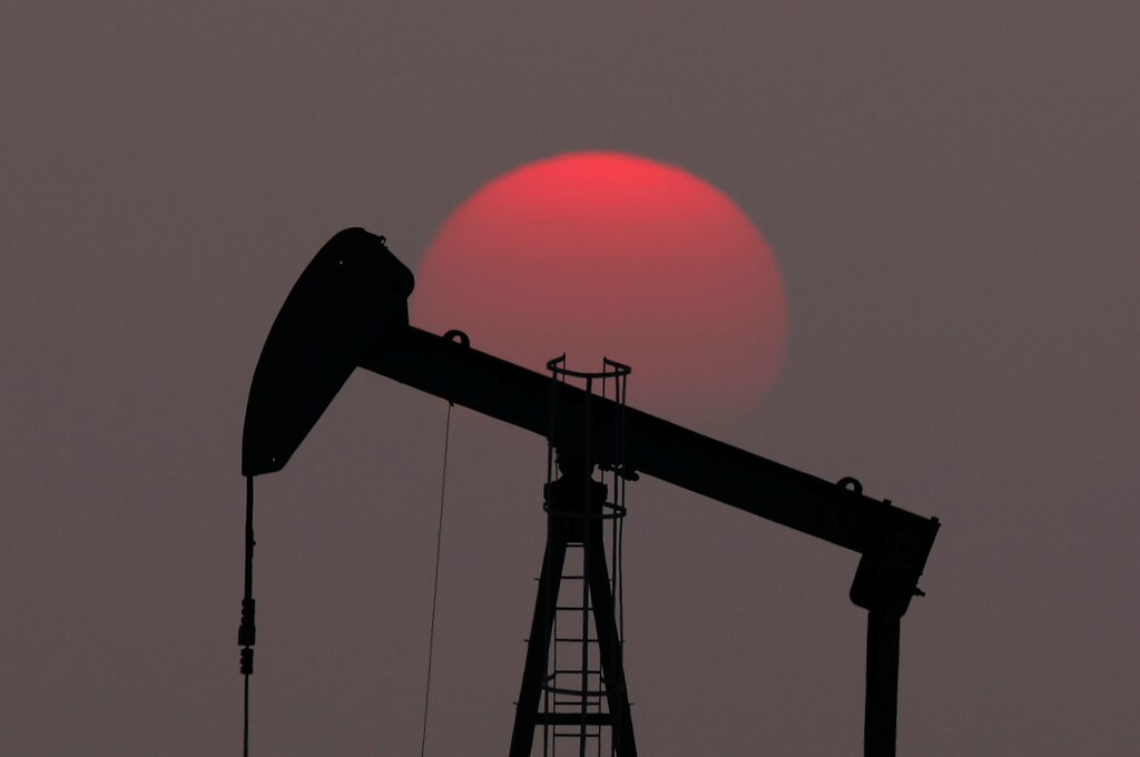 The sun sets behind an oil pump outside Saint-Fiacre, near Paris, France March 28, 2019. REUTERS/Christian Hartmann - RC1D563A0010
