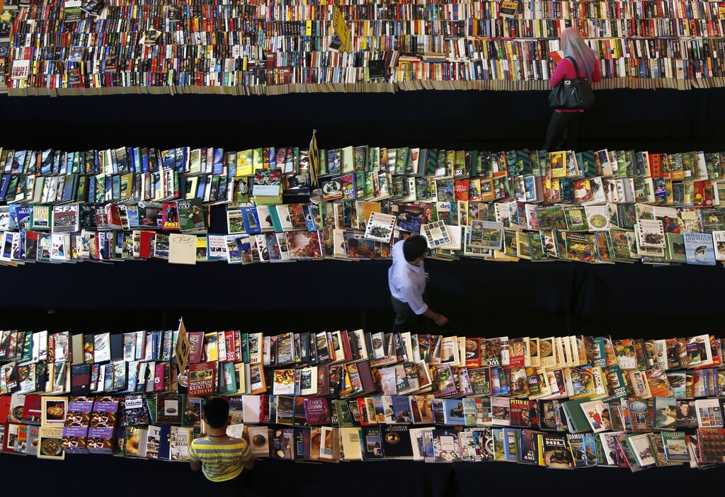 People browse books at a book stall in Petaling Jaya, outside Kuala Lumpur October 16, 2013. REUTERS/Samsul Said (MALAYSIA - Tags: SOCIETY BUSINESS MEDIA TPX IMAGES OF THE DAY) - GM1E9AG16J601