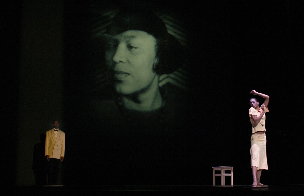 Dancers Briana Reed (R) and Michael Francis McBride (L), with the Alvin Ailey American Dance Theater perform under an image of Zora Neale Hurston in "Uptown", a new work choreographed by 18-year company veteran Matthew Rushing during a dress rehearsal for tonight's World Premiere at New York's City Center December 9, 2009. REUTERS/Mike Segar (UNITED STATES ENTERTAINMENT) - GF2E5C91MJX01