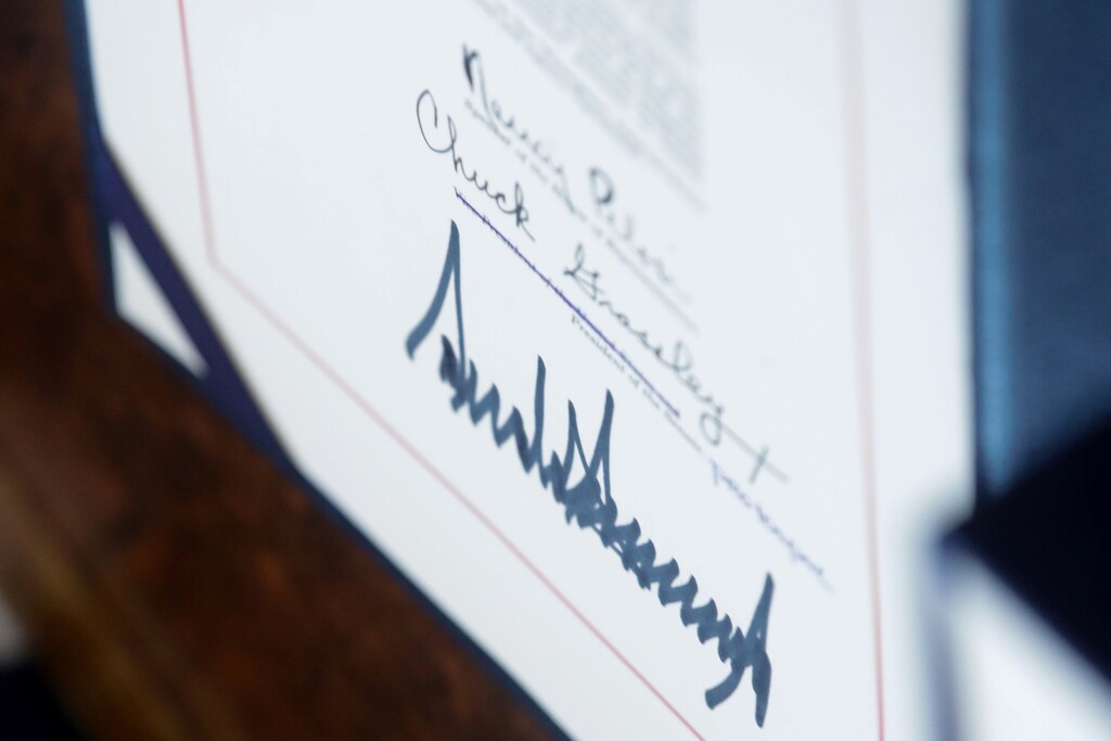 U.S. President Donald Trump's signature is seen below the signatures of Speaker of the House Nancy Pelosi and U.S. Senate President pro tempore Senator Chuck Grassley after the president signed the $2.2 trillion coronavirus CARES Act aid package bill into law in the Oval Office of the White House in Washington, U.S., March 27, 2020. REUTERS/Jonathan Ernst - RC2LSF9NJFBA