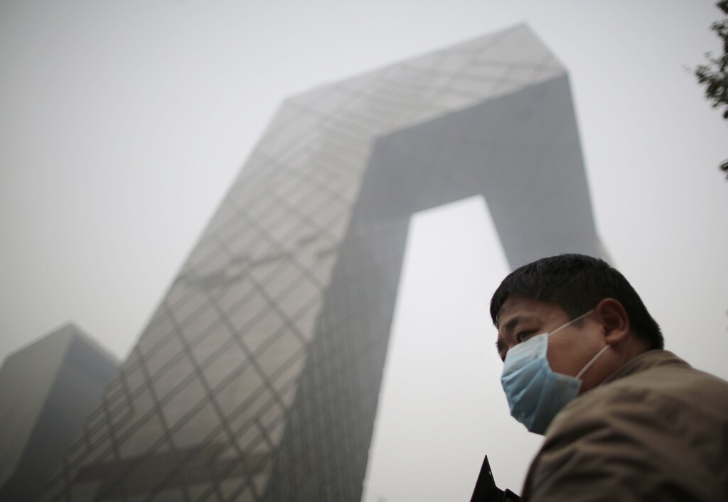 A man wearing a mask walks on a street on a hazy day in Beijing October 24, 2014. REUTERS/Kim Kyung-Hoon (CHINA - Tags: ENVIRONMENT SOCIETY) - GM1EAAO1ENZ01