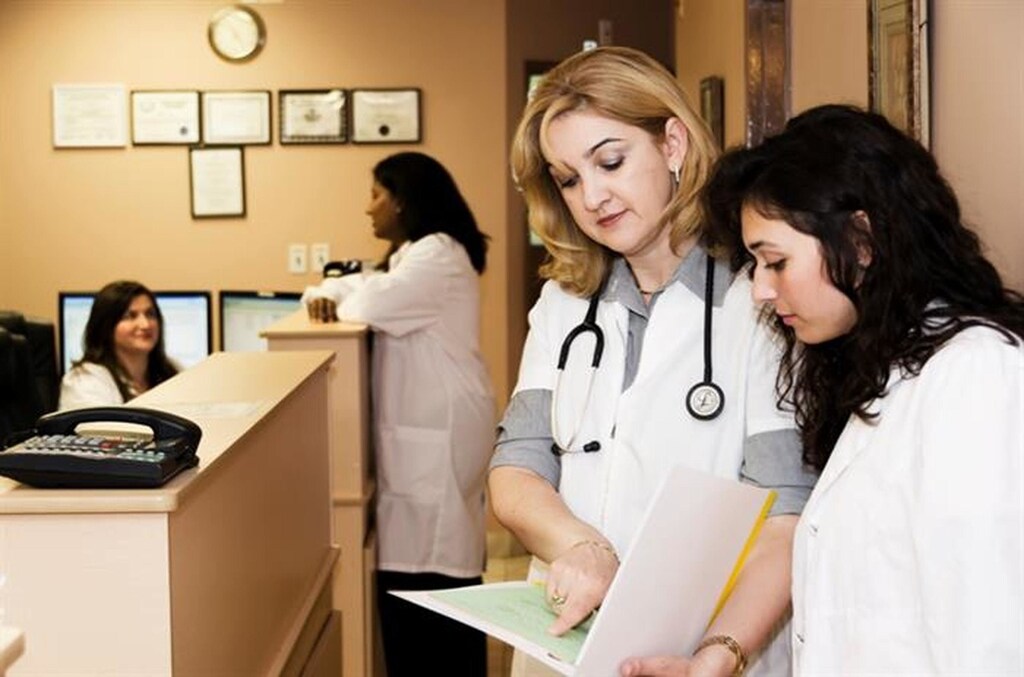 Two female medical practitioners looking at a document in a medical office.