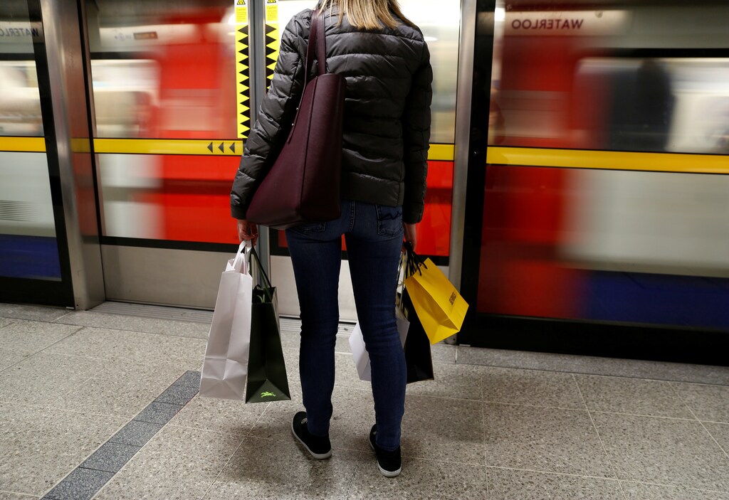 A woman carries her shopping bags before boarding a train on the London Underground at Waterloo Station in London, Britain, November 25, 2017.