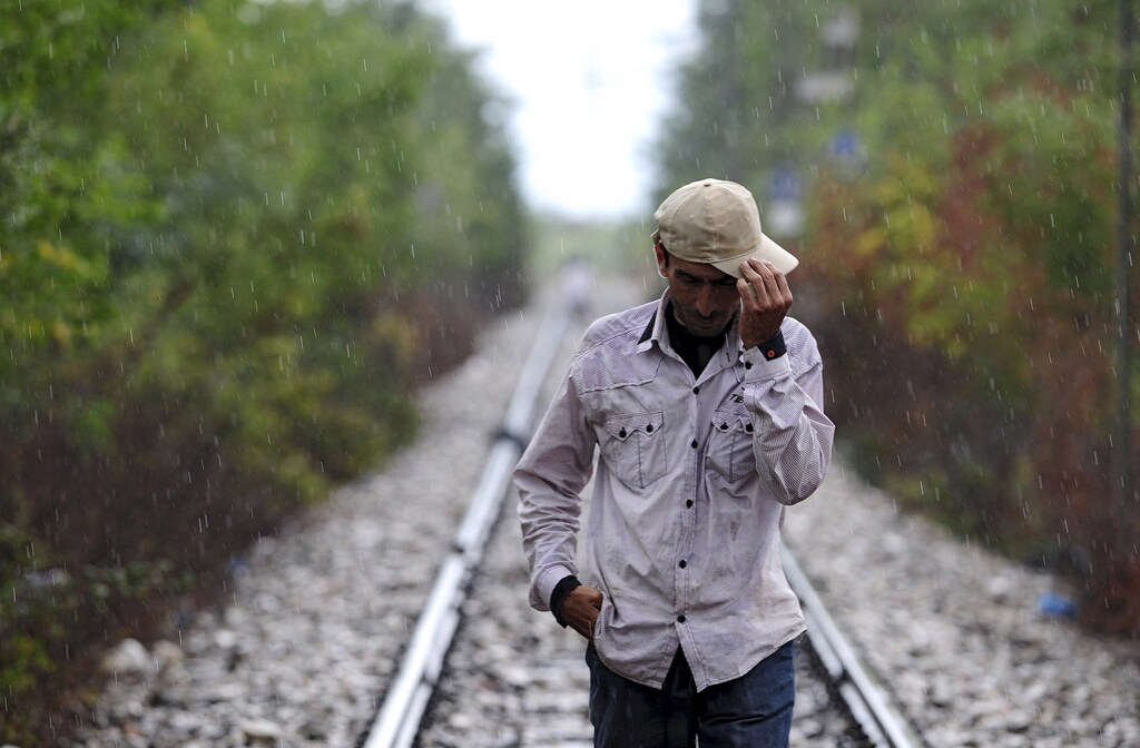 A migrant walks towards Gevgelija in Macedonia after crossing Greece's border, Macedonia, August 22, 2015. Thousands of migrants stormed across Macedonia's border on Saturday, overwhelming security forces who threw stun grenades and lashed out with batons in an increasingly futile bid to stem their flow through the Balkans to western Europe. Some had spent days in the open with little or no access to food or water afterMacedonia on Thursday declared a state of emergency and sealed its borders to migrants, many of them refugees from war in Syria and other conflicts in the Middle East. REUTERS/Ognen Teofilovski - RTX1P820
