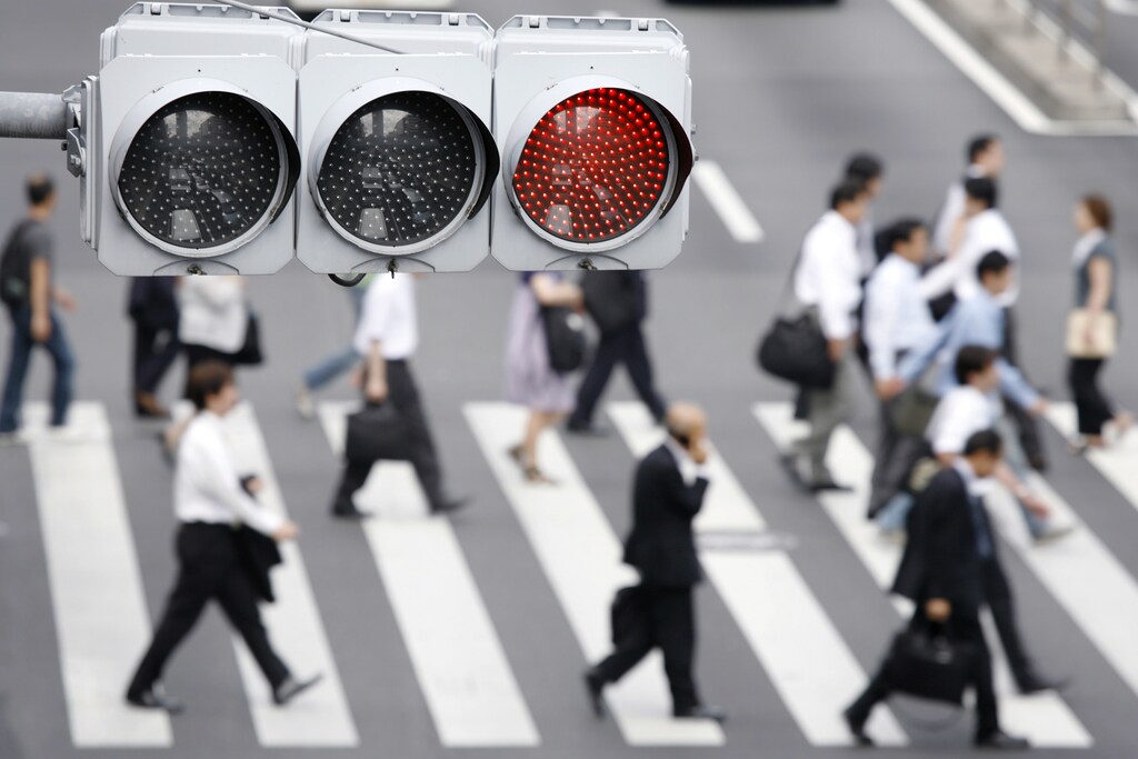 A traffic light is seen while pedestrians cross a street in Tokyo August 3, 2009. REUTERS/Stringer (JAPAN BUSINESS EMPLOYMENT) - GM1E58J0UGT01
