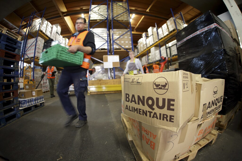 Volunteers at the "Banques Alimentaires" (Food Bank) move palettes in their warehouse in Arcueil, France, May 26, 2015. France is cracking down on food waste with legislation banning supermarkets from destroying unsold but edible food on pain of fines and even jail sentences. The new bill is to be voted on by France's lower house of parliament on May 26 and then sent to the Senate. REUTERS/Philippe Wojazer - RTX1EKSV