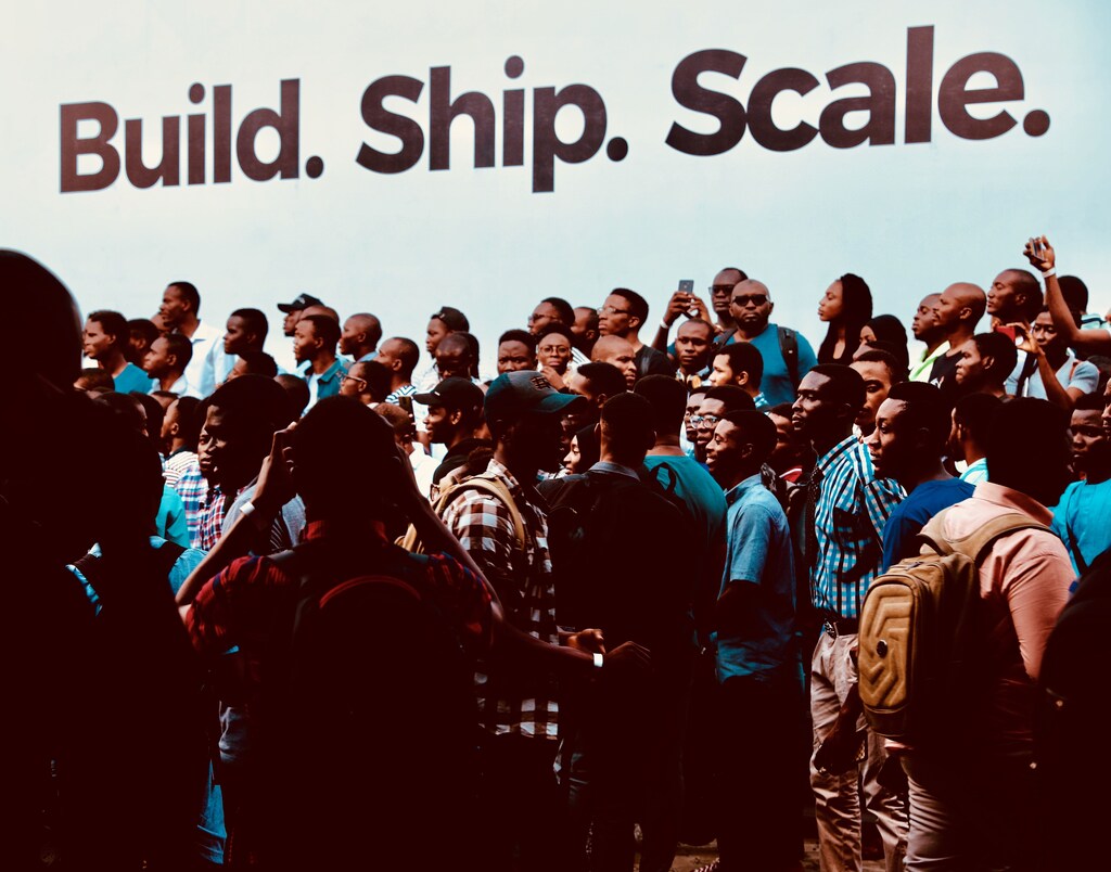 A group of people standing in front of a building: People learn skills and ideas within communities that are impossible to replicate elsewhere.