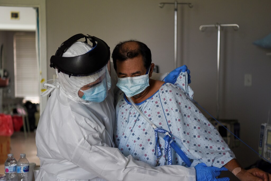 Fernando Olvera, 26, a medical school student, helps Efrain Guevara, 63, who has been hospitalised with COVID-19, get up from his hospital bed, at United Memorial Medical Center (UMMC), during the coronavirus disease (COVID-19) outbreak, in Houston, Texas, U.S., July 17, 2020. REUTERS/Callaghan O'Hare TPX IMAGES OF THE DAY SEARCH "COVID-19 HOUSTON VARON" FOR THIS STORY. SEARCH "WIDER IMAGE" FOR ALL STORIES. TPX IMAGES OF THE DAY - RC213I95H8IC