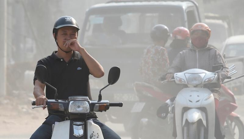 A man covers his nose as he drives through an air polluted street in Hanoi, Vietnam October 1, 2019. REUTERS/Kham - RC1CC4679CB0