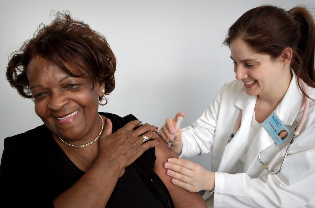 Person receiving a vaccination from a nurse.