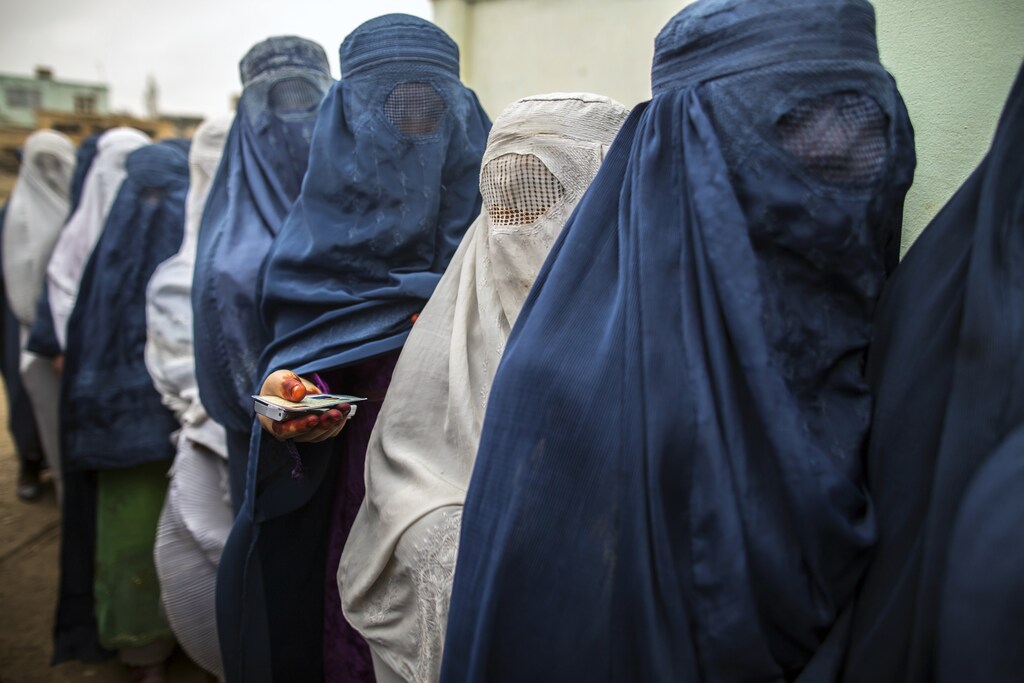 Afghan women stand in line while waiting for their turn to vote at a polling station in Mazar-i-sharif April 5, 2014. Voting was peaceful during the first few hours of Afghanistan's presidential election on Saturday, with only isolated attacks on polling stations as the country embarked on the first democratic transfer of power since the fall of a Taliban regime in 2001. REUTERS/Zohra Bensemra (AFGHANISTAN - Tags: POLITICS ELECTIONS TPX IMAGES OF THE DAY) - GM1EA4519JT01
