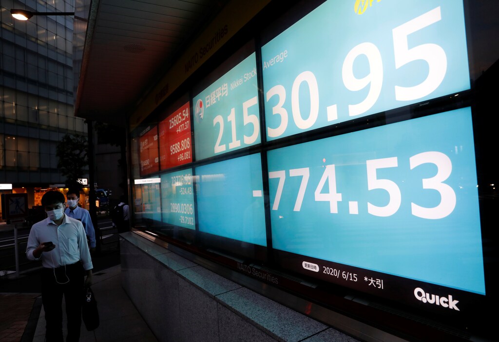 Men wearing protective face masks, following the coronavirus disease (COVID-19) outbreak, walk past a stock quotation board outside a brokerage in Tokyo, Japan, June 15, 2020. REUTERS/Kim Kyung-Hoon - RC2N9H9OF28W