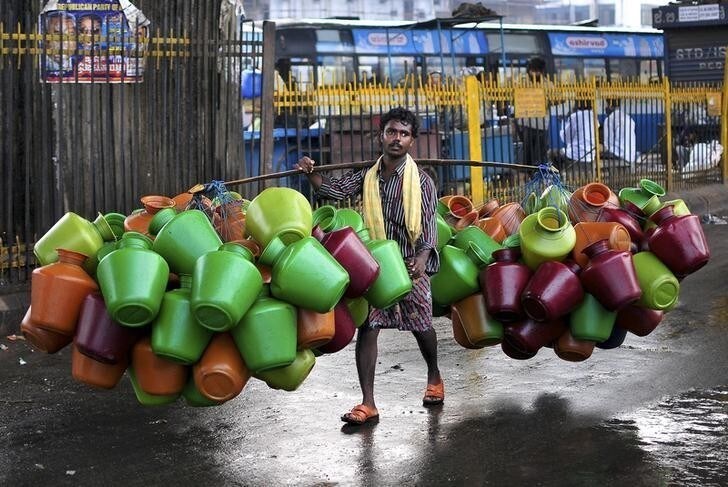 A man carries empty water pitchers for sale in a market in the southern Indian city of Bangalore October 9, 2014. REUTERS/Abhishek N. Chinnappa (INDIA - Tags: SOCIETY TPX IMAGES OF THE DAY)