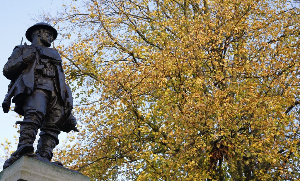 A statue of a First World War soldier is seen on top of a war memorial in front of autumnal trees near Manchester, northern England October 26, 2011. REUTERS/Phil Noble