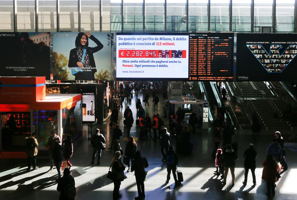 People walk past a "debt clock" screen, installed by Bruno Leoni Institute's analysts, displaying Italy's public debt at the Termini central station in Rome, Italy February 15, 2018. REUTERS/Alessandro Bianchi - RC1AFF944460