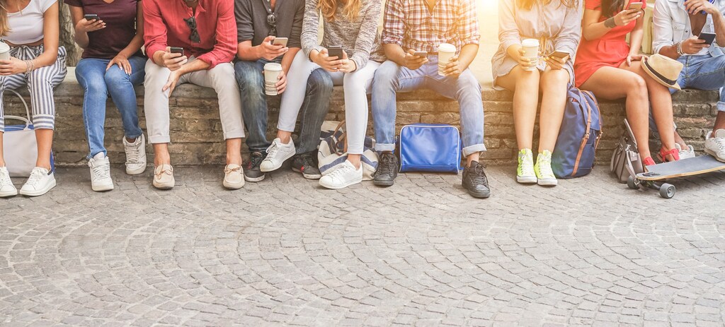 Young friends using smartphones and drinking coffee outdoor - Group of people having fun with technology trends - Youth, new generation addiction and friendship concept - Main focus on center guys; Buy now, pay later, online shopping