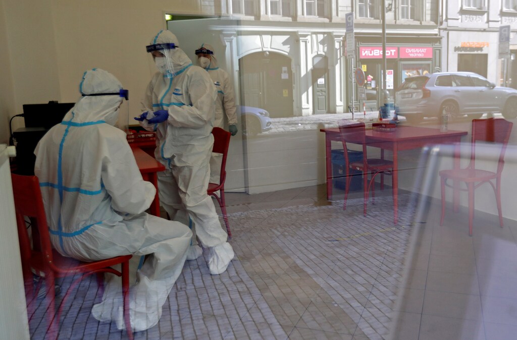 Medical staff members wearing protective suits are seen through a window, waiting for people who will be tested for the coronavirus disease (COVID-19) inside a newly opened sampling station in Prague, Czech Republic, October 1, 2020. REUTERS/David W Cerny - RC2M9J9HFT38