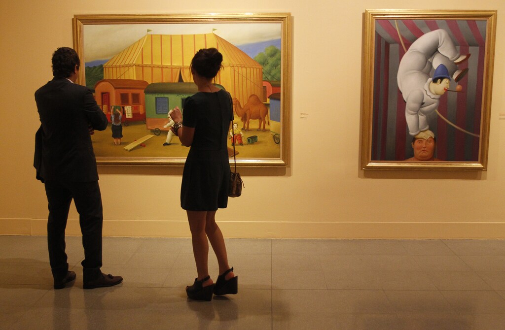 People look at a painting by Colombian painter and sculptor Fernando Botero during the opening of his exhibition "The Circus" at the Museum of Antioquia