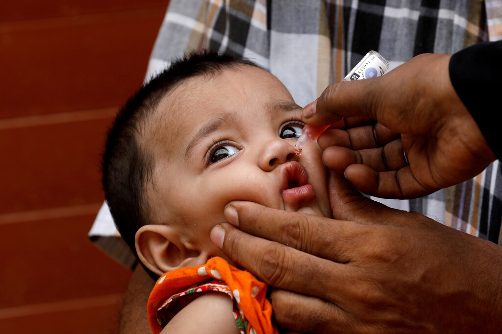 FILE PHOTO: A girl receives polio vaccine drops, during an anti-polio campaign, in a low-income neighborhood as the spread of the coronavirus disease (COVID-19) continues, in Karachi, Pakistan July 20, 2020. REUTERS/Akhtar Soomro/File Photo