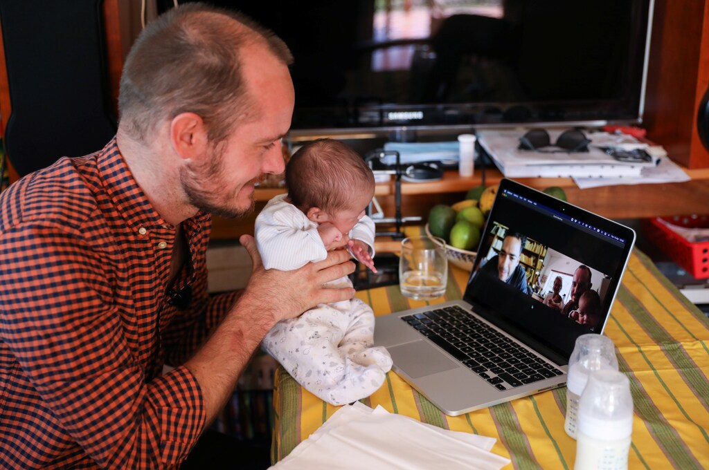 a man shows up a baby on a zoom call