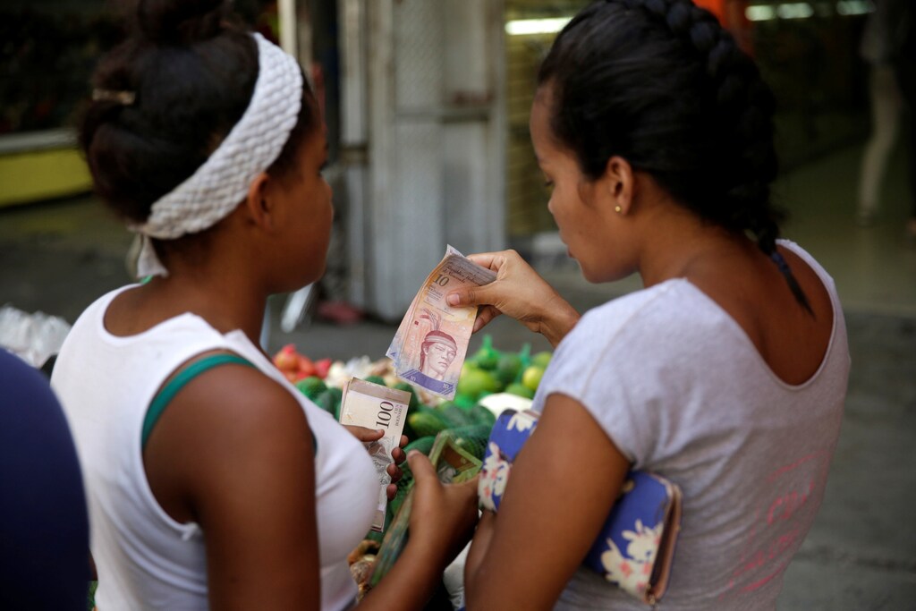 Women count Venezuelan bolivar notes at a street market in the slum of Petare in Caracas, Venezuela, December 12, 2016. REUTERS/Marco Bello - RTX2UQJM