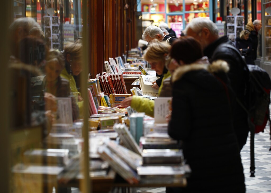 People browse through shelves outside a book store in the covered Jouffroy passage with its shops and businesses in Paris, France, March 2, 2016. REUTERS/Mal Langsdon - RTS8Z3F